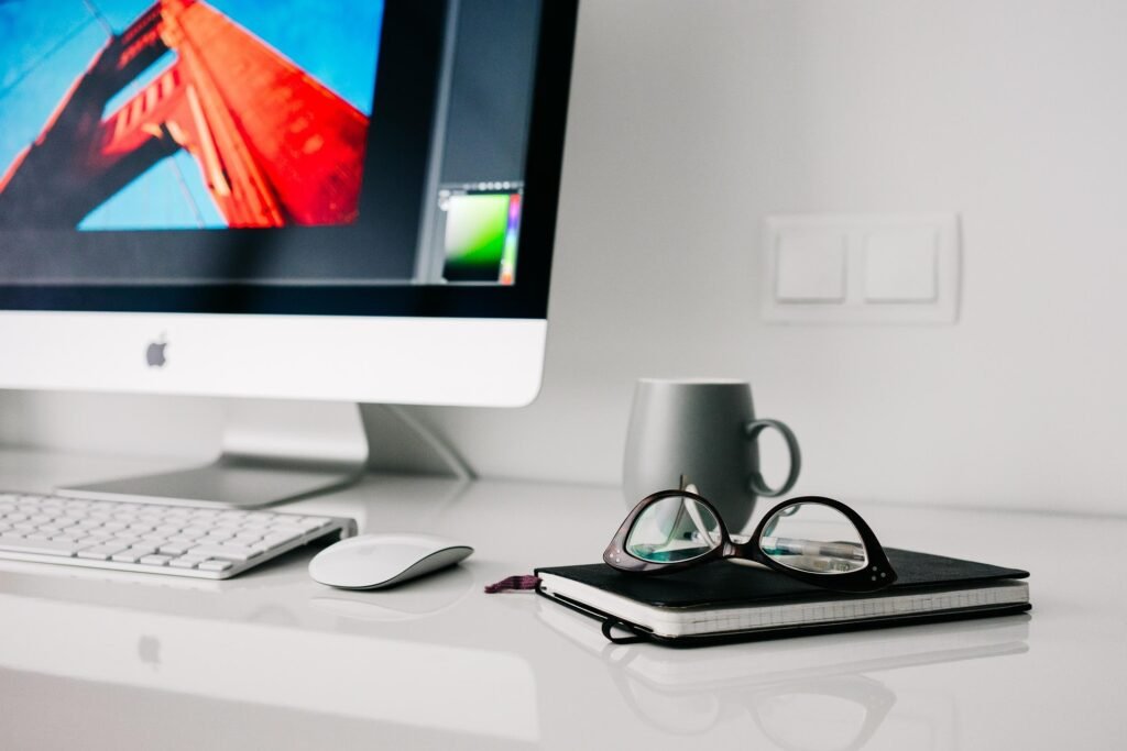 Espace de travail moderne avec un ordinateur portable et un carnet de notes, illustrant l'environnement de travail d'Amrane Setbel, Webmaster et E-commerçant.